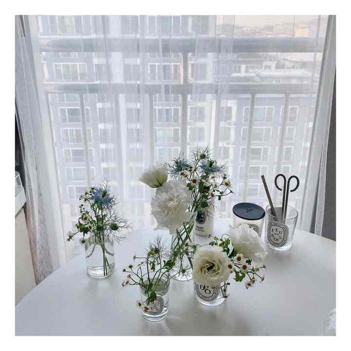 White and natural tone space featuring vases and candles arranged on a bright, clean table interior