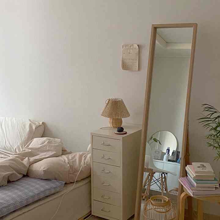 白い壁とナチュラルな木目調家具が配置された一人暮らし用寝室、落ち着いた雰囲気のインテリア