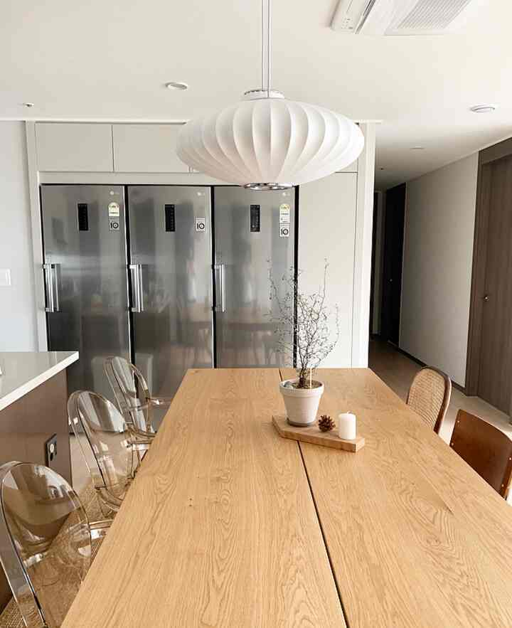 Natural tone dining room featuring a wooden dining table and mixed chairs in a clean, modern family space