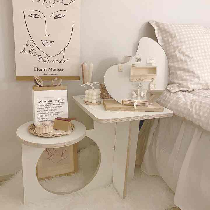 Cozy bedroom space harmonizing white and wood tones, featuring a stylish nightstand and unique mirror beside the bed with a calming atmosphere