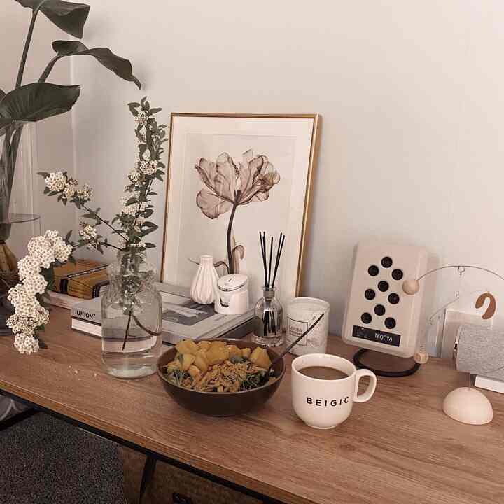 A natural spring bedroom with beige and wood tone, featuring a low table with vases, coffee cup, and picture frame