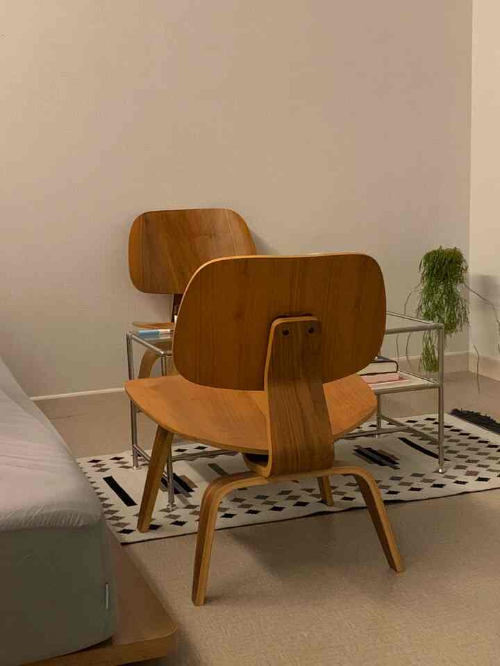 Natural wood tone and white background small studio apartment featuring minimalist furniture and a coffee table with a simple atmosphere