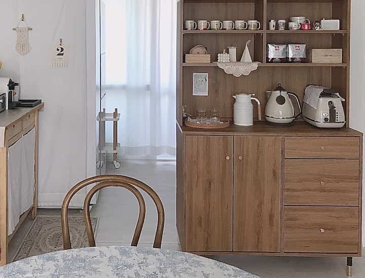 Ivory and wood tone kitchen featuring wooden drawers and home cafe coffee equipment creating a cozy atmosphere