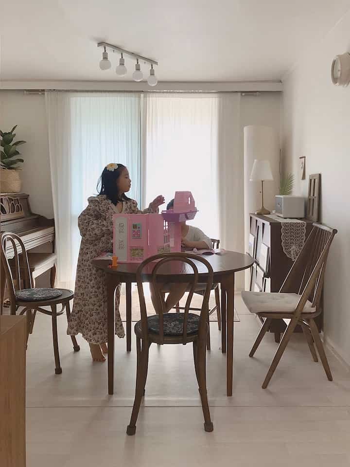Natural toned living and dining room featuring a round dining table with chairs, cozy family space with soft lighting