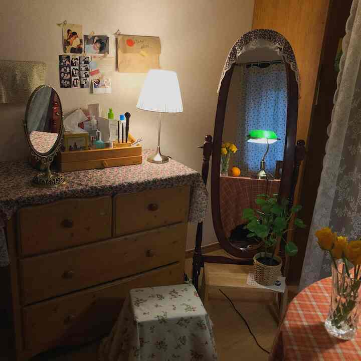 Natural beige-toned powder room featuring wood-tone furniture, floral vase, lace curtains, creating cozy and warm atmosphere