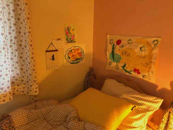 Yellow and beige bedroom with floral curtains and checkered bedding creating a cozy atmosphere