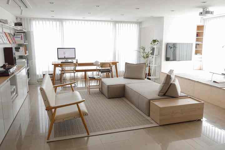 Bright white and beige toned living room featuring Como sofa and wooden desk, creating a calm modern space