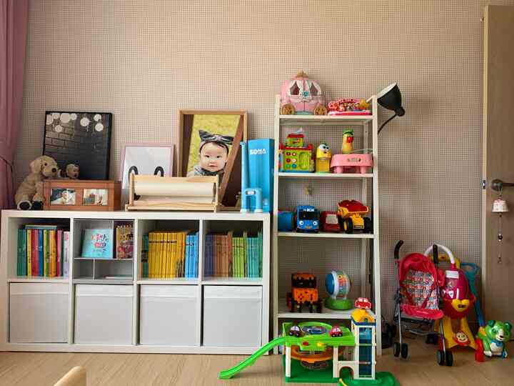 明るいホワイトとベージュの色調の子供部屋、カラックス収納とおもちゃが整頓された清潔で居心地の良い空間