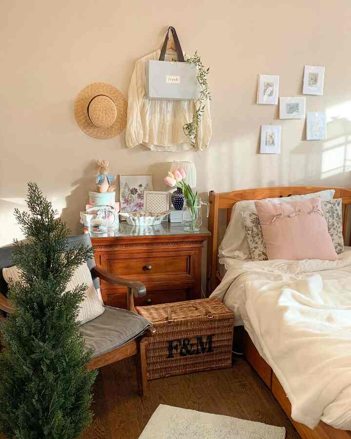 Cozy bedroom with soft beige walls and wooden furniture, accented by pink cushions and tulips