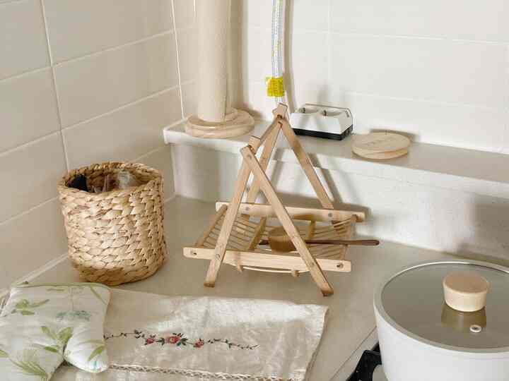 ナチュラルカラーとウッドトーンが調和したキッチン、木製の食器と白いテーブルクロスが置かれた雰囲気のある空間