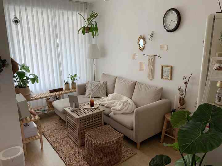 ナチュラルな色調のリビング、ベージュのソファと木目調の家具が配置された落ち着いたインテリア