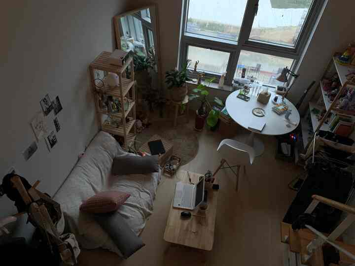Natural wood tones and white in a single household living room with wooden coffee table and dining set creating a cozy atmosphere
