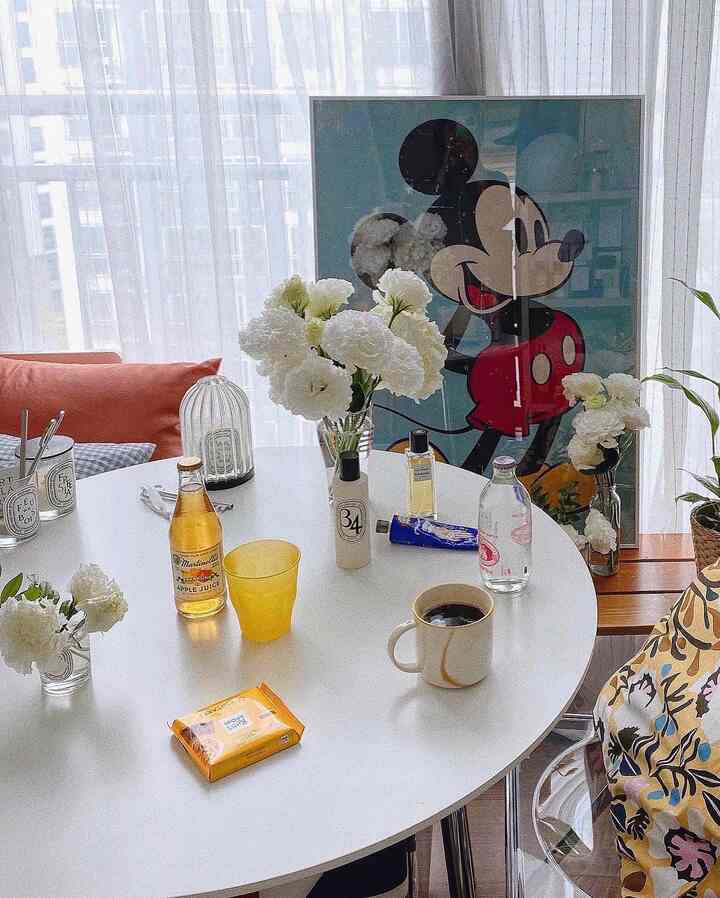 White-toned round table and Disney framed poster in a cozy home cafe space