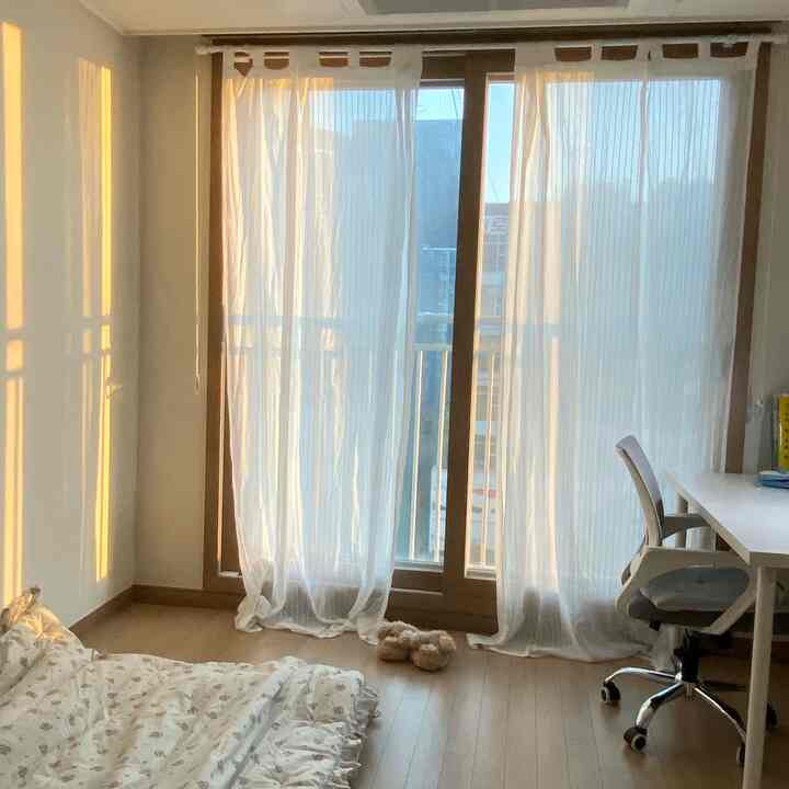 Natural-toned 6-pyeong studio bedroom with white and wood tones, featuring bedding on the floor and a desk setup