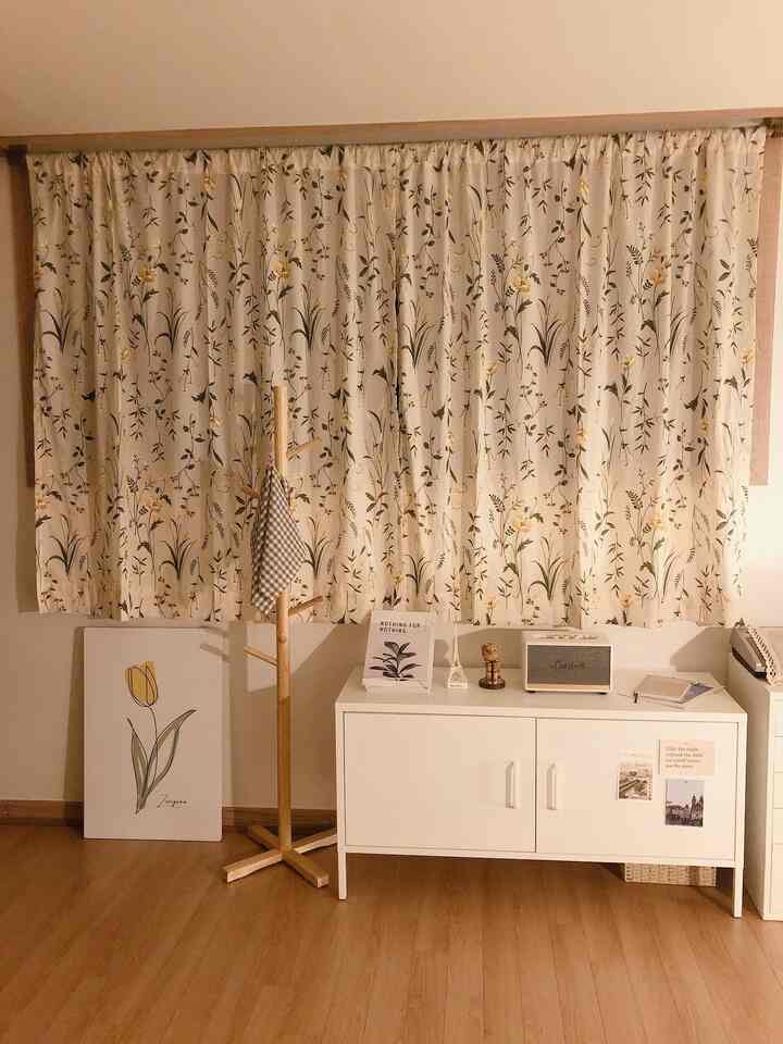 Beige and wood tone living room featuring a white cabinet and floor stand with a cozy atmosphere