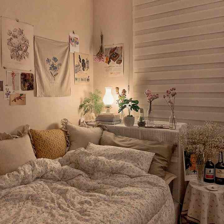 暖かいベージュとナチュラルトーンの寝室、ヴィンテージランプと観葉植物が配置された雰囲気のあるインテリア