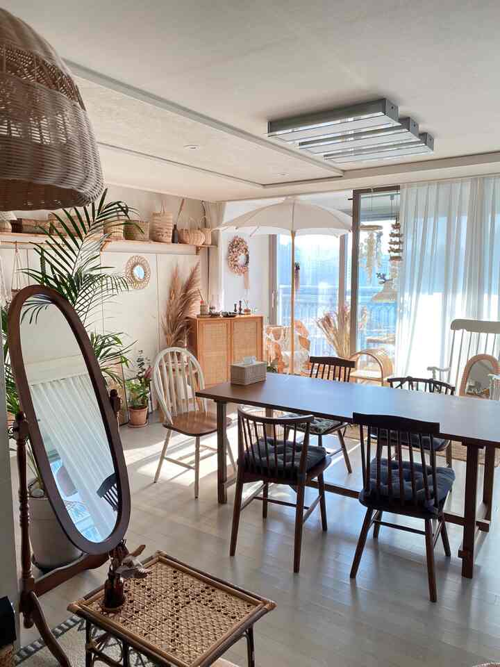 Bright and cozy living room with natural wood tones and rattan furniture connected to a balcony