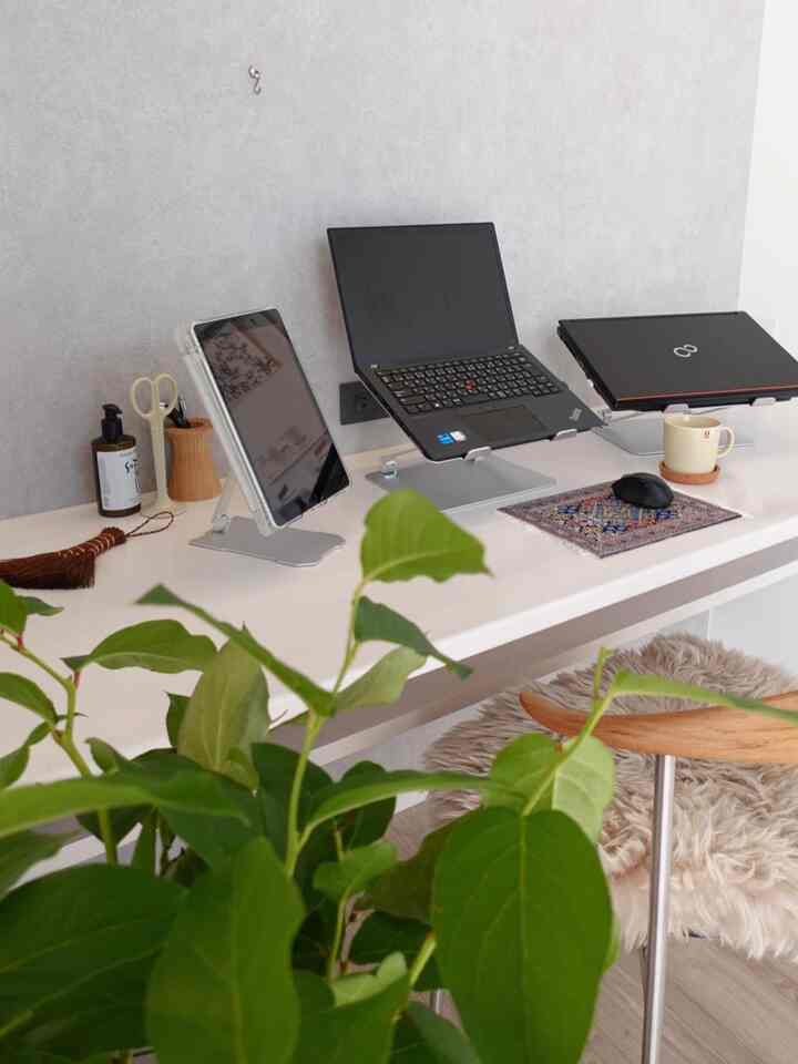 白を基調としたホームオフィス、BoYataのノートパソコンとiPadスタンド、緑の植物が配置された雰囲気のあるインテリア
