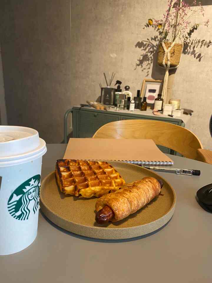 Natural-toned home office space featuring a plate with food and a Starbucks coffee cup, creating a warm home cafe atmosphere
