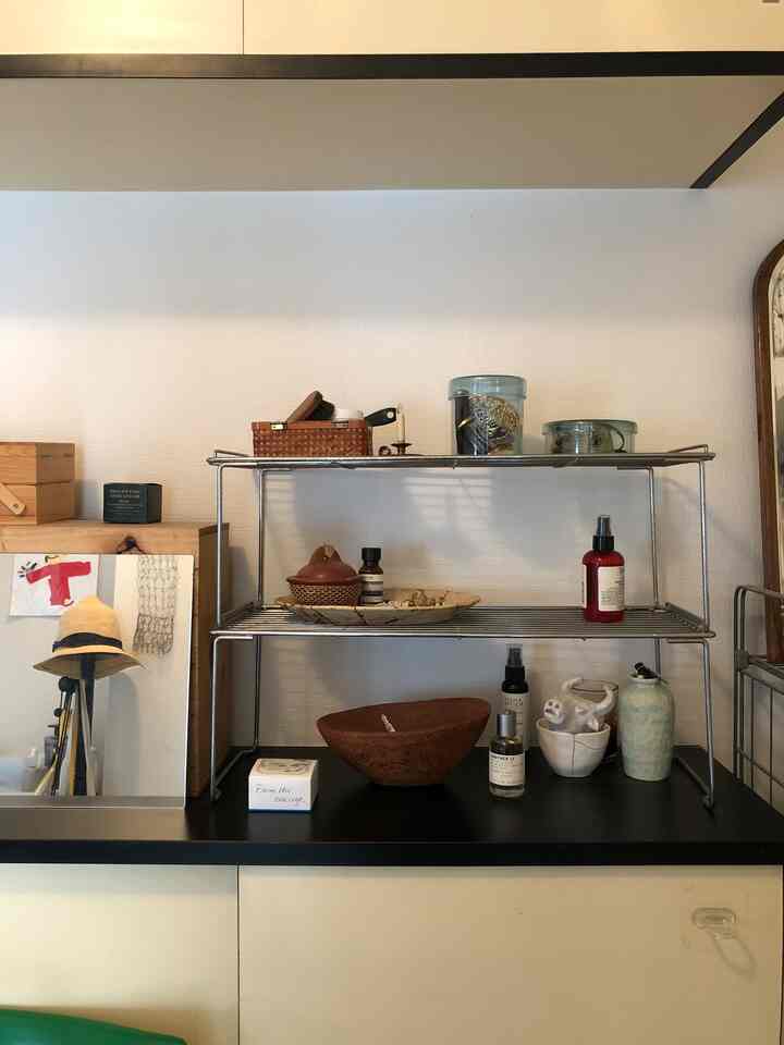 白い壁と黒い収納の玄関、ナチュラルな装飾と鏡が配置された整頓された空間