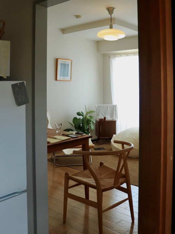 ナチュラルな色調のダイニング、木製の椅子とペンダントライトが配置された雰囲気のあるインテリア