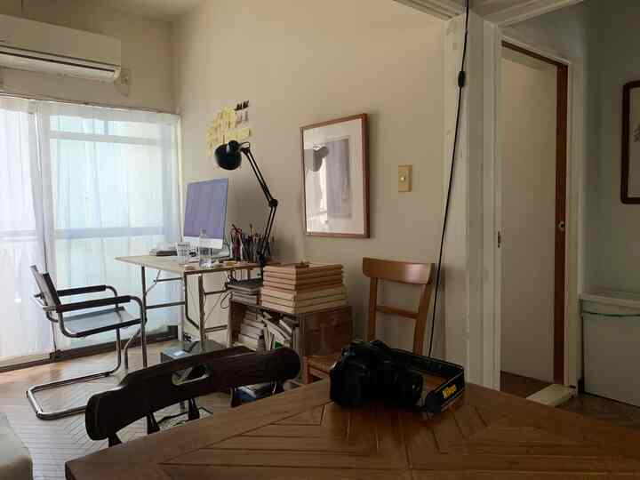 Beige-toned walls and wood-toned furniture blend in a home office and dining room space with a neat, cozy atmosphere