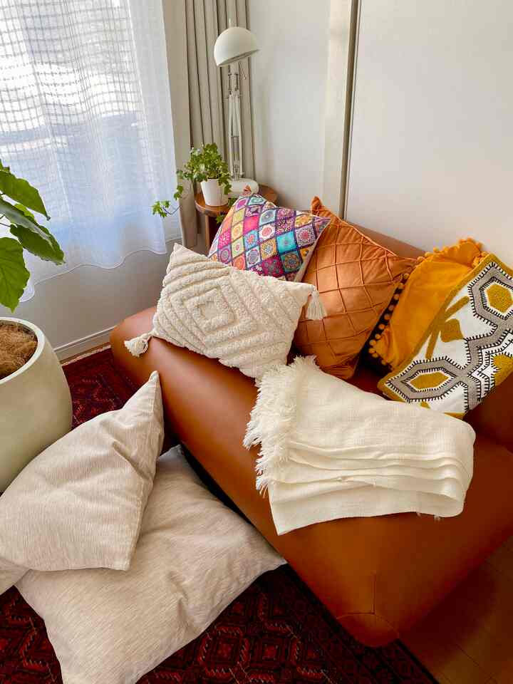 Warm brown toned living room with vintage sofa and colorful cushions creating a cozy atmosphere