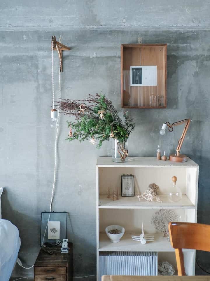 ナチュラルでウッド調のホワイトが調和したダイニング、コンクリート壁とミニマルな装飾が雰囲気のあるインテリア