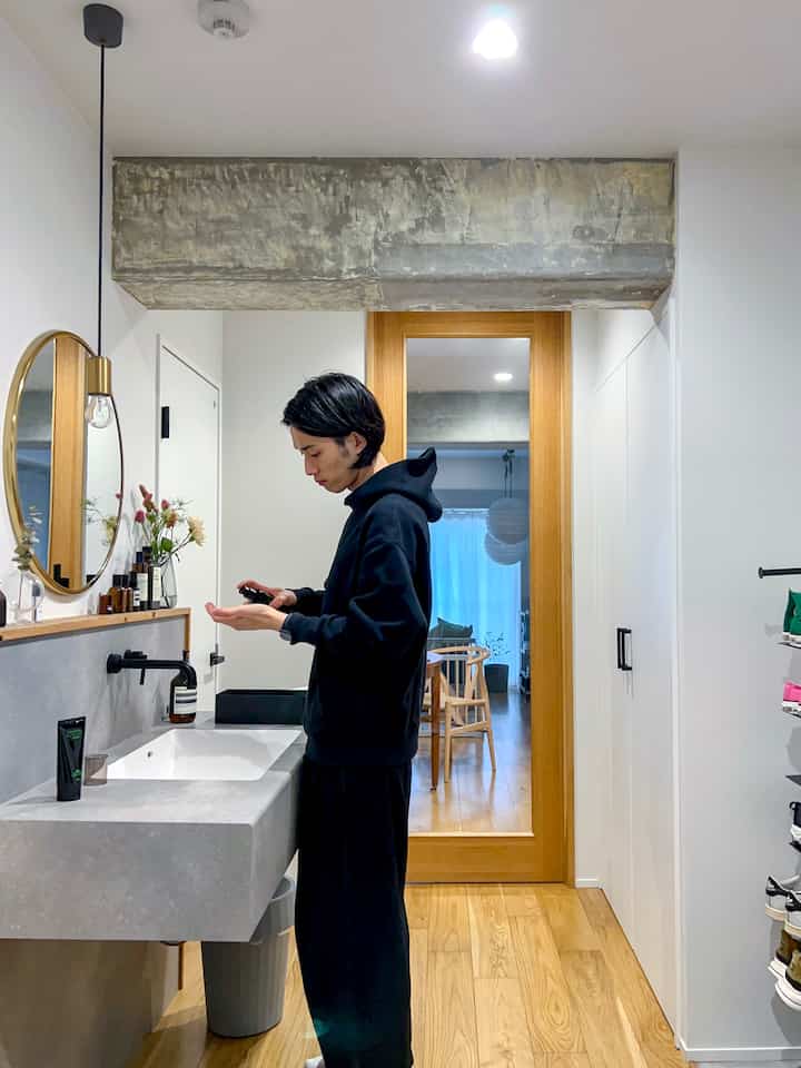 A white and wood-toned long narrow hallway entrance featuring a modern vanity and organized shoe storage