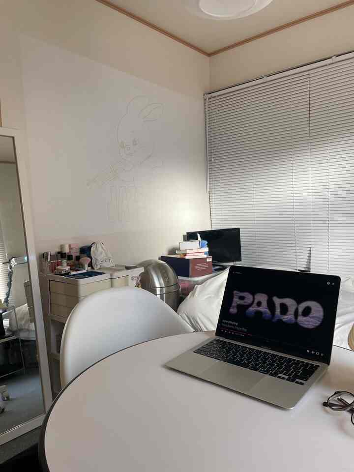 白を基調としたコンパクトな部屋、ノートパソコンとデスクが配置されたモダンなホームオフィスの雰囲気のあるインテリア