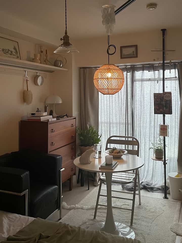 Natural color compact dining room for single household featuring wood furniture and a pendant light with warm ambiance