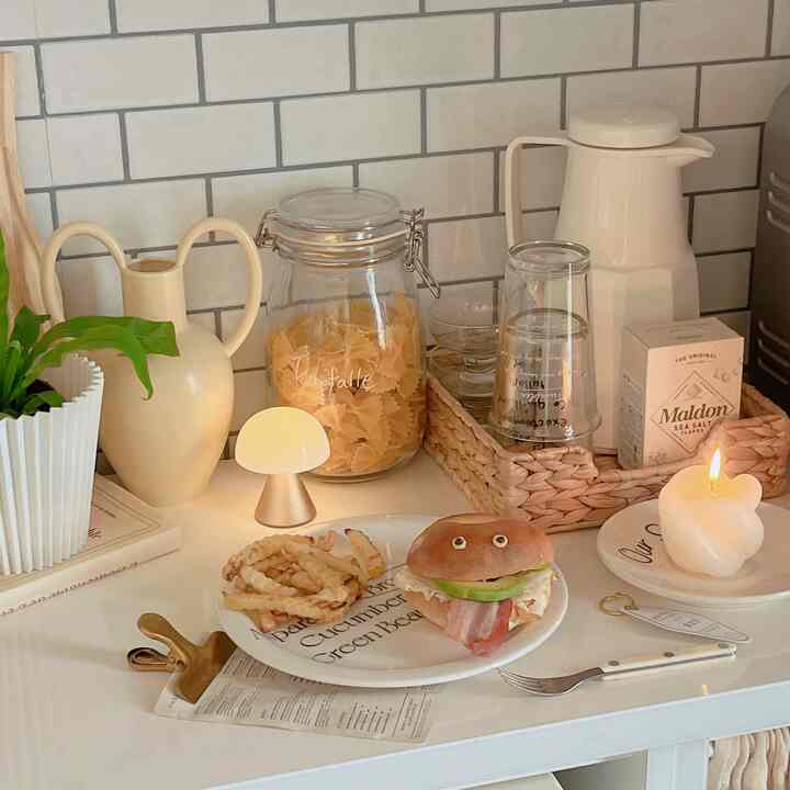 ベージュとホワイトのトーンのキッチン、ホームカフェのセッティングとキャンドルが温かみのある雰囲気を醸し出すインテリア