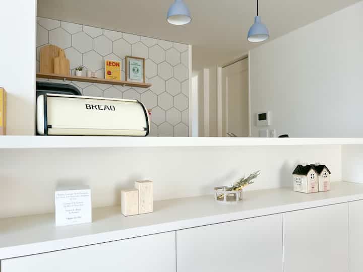 白とナチュラルカラーのダイニング、シンプルな印象の棚とキャビネットが配置された収納空間