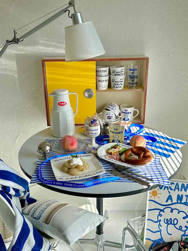 白と青の色調のダイニング、丸テーブルにはマグカップやプレッツェルが置かれ、温かみのあるおうちカフェの雰囲気があるインテリア