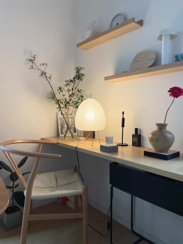 白い壁と自然な木目調のデスクと椅子が配された、ナチュラルモダンな雰囲気のインテリア空間