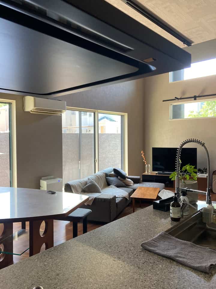 White and gray with wood tones blend in the kitchen and living room, featuring modern natural style and cozy atmosphere