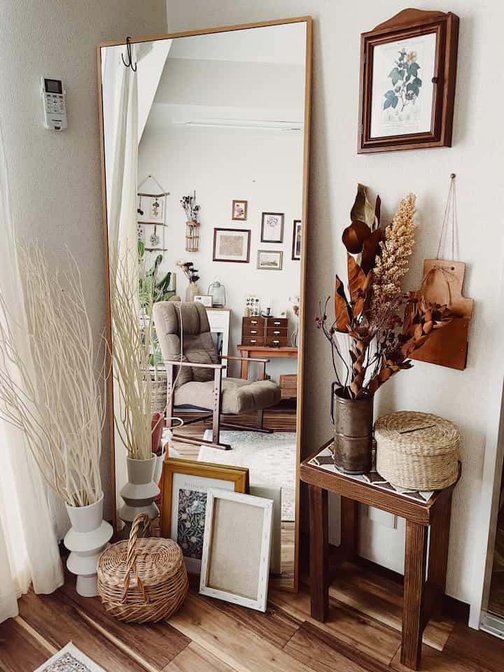 ナチュラルな木目調の鏡と額縁が配置された、落ち着いた雰囲気のあるナチュラルスタイルの空間