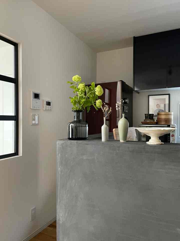 グレーとネイビーのトーンが特徴的なキッチン、中央に花瓶が配置されたモダンなインテリア