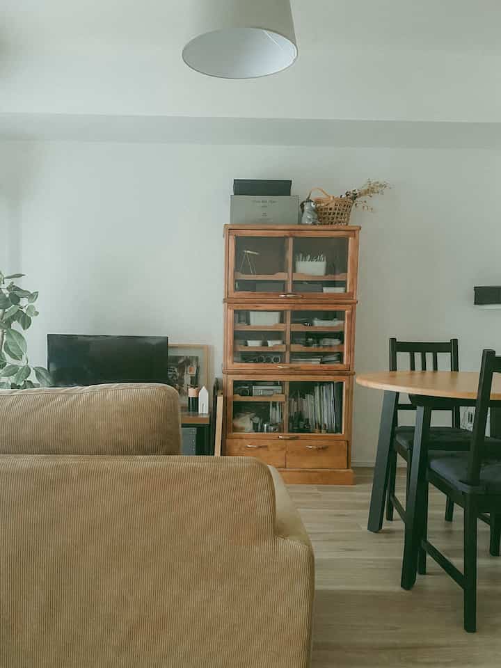 ベージュのソファと木目調の家具が調和した1LDKリビング、温かみのあるナチュラルな雰囲気のインテリア