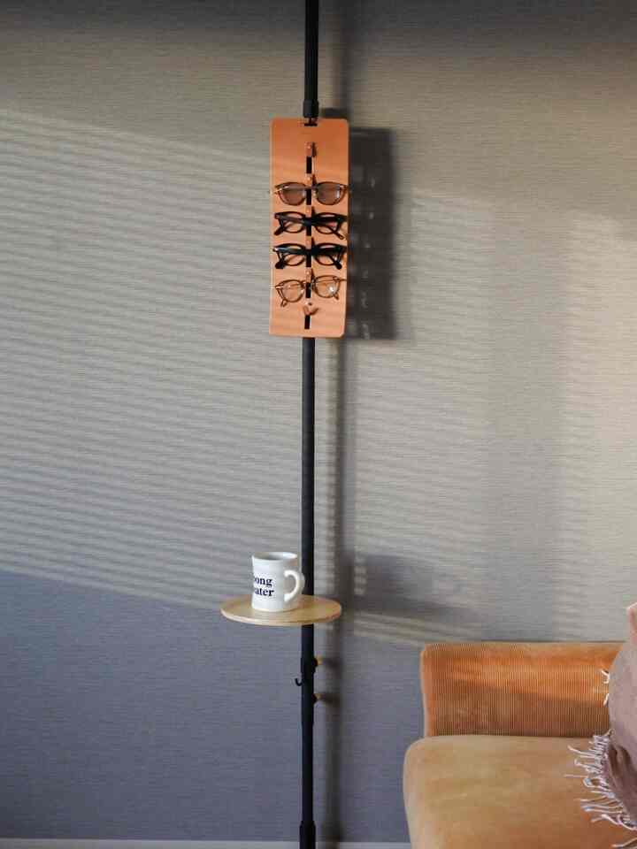 A brown tone living room wall features an orange glasses holder and a brown sofa beside it creating a cozy space