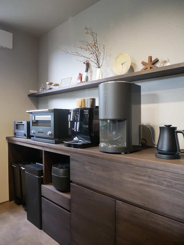 Cozy kitchen space with dark brown wooden cabinets topped with black and dark gray appliances