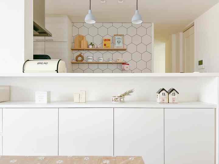 White and natural-toned kitchen space featuring simple objets and candle decorations creating a clean atmosphere