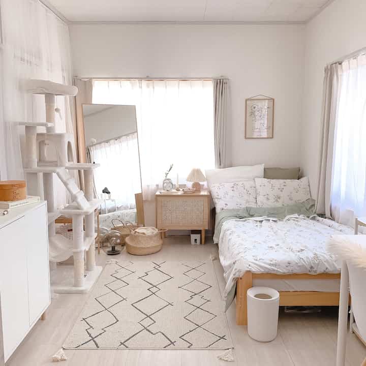 Bright white and natural-toned 6-tatami bedroom featuring cat tower, wooden furniture, and a clean cozy atmosphere