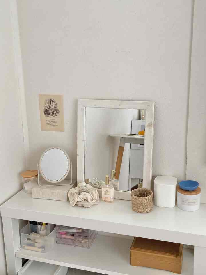 Simple vanity area featuring white and natural tones with various mirrors and accessories in harmonious interior