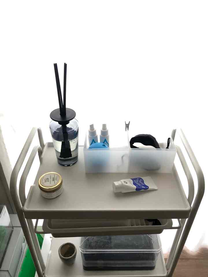 白黒のトーンのユーティリティシェルフにディフューザーと収納用品が整然と配置された清潔な空間