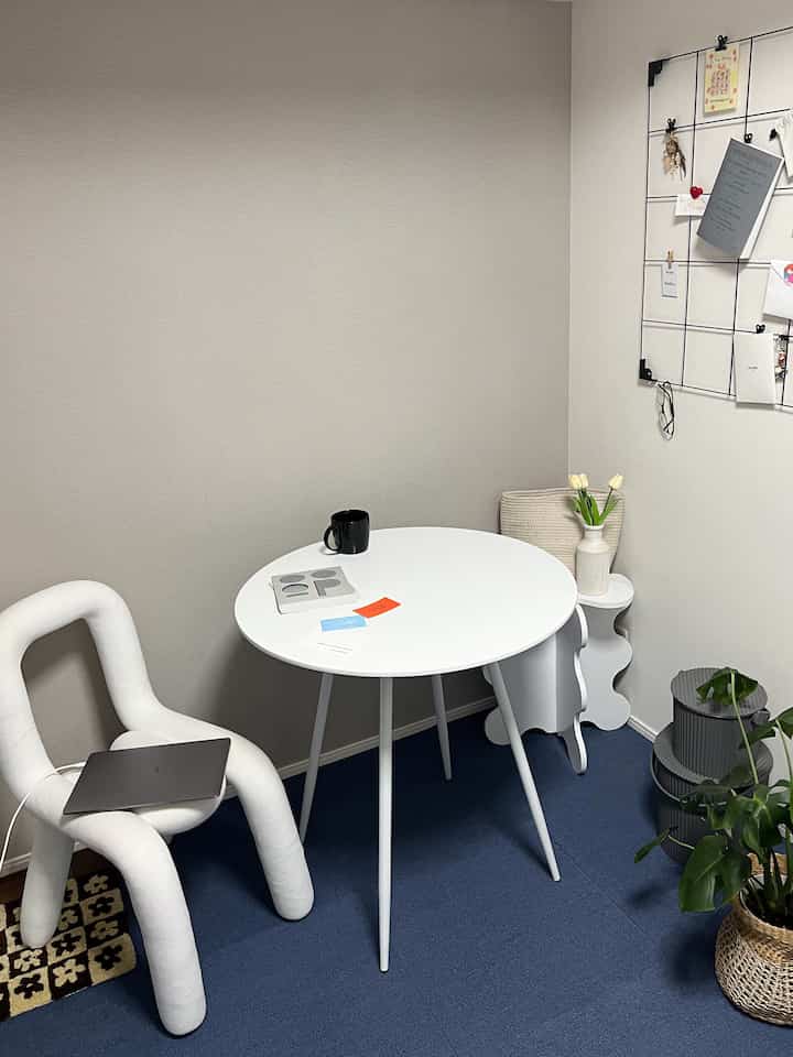 Blue and white toned dining room featuring a round dining table and unique chair with a simple aesthetic