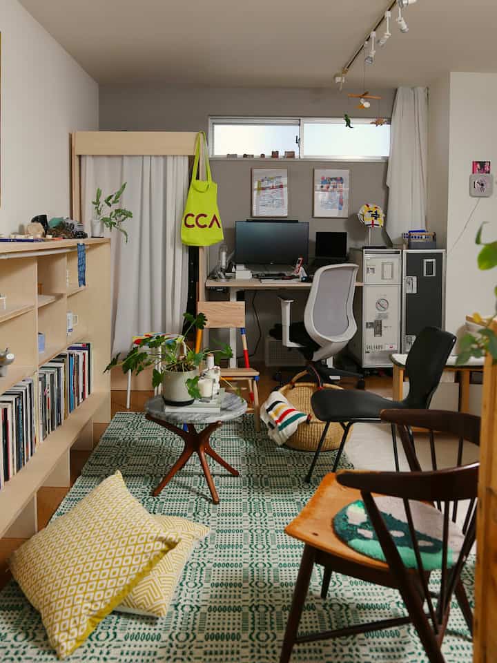 Natural toned small single household room featuring multiple chairs and stools in a cozy home office setup