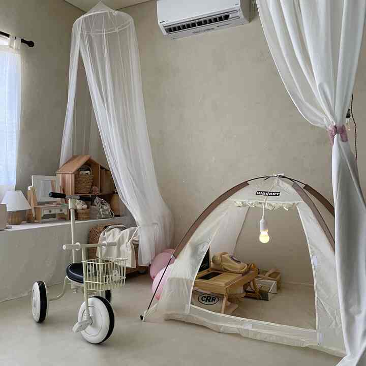 ナチュラルカラーの子供部屋、布とテントが配置された雰囲気のあるキッズプレイスペース
