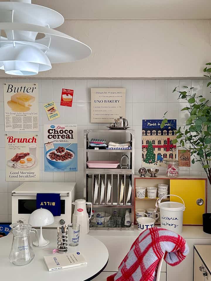 Natural white-toned dining room with a round dining table and stainless steel shelves creating a clean atmosphere