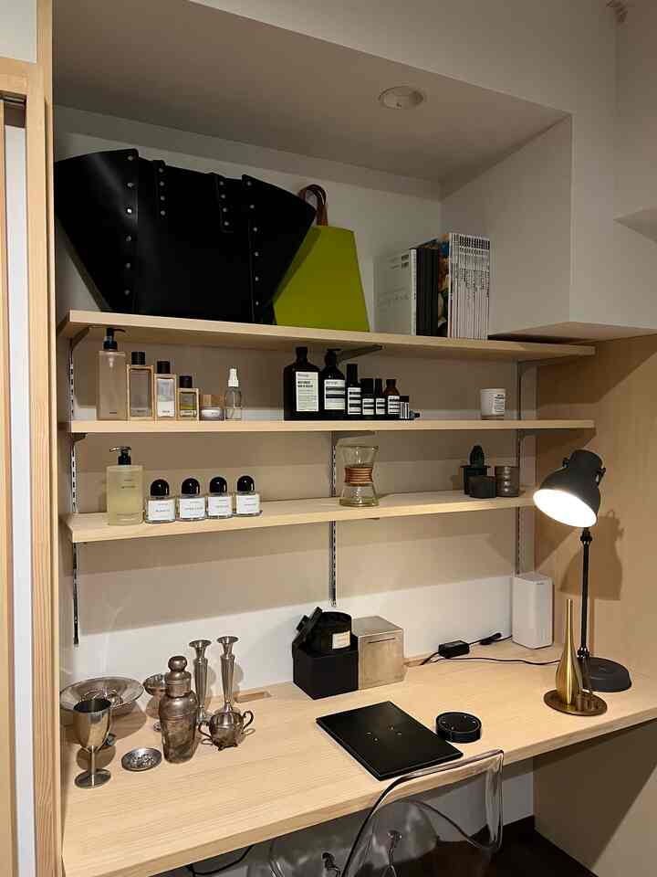 Natural and white toned focus space home office featuring organized shelves and a table lamp, with a clean atmosphere